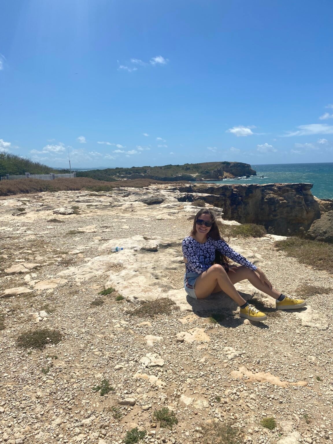 la mujer está sentada a orillas de los acantilados de cabo rojo