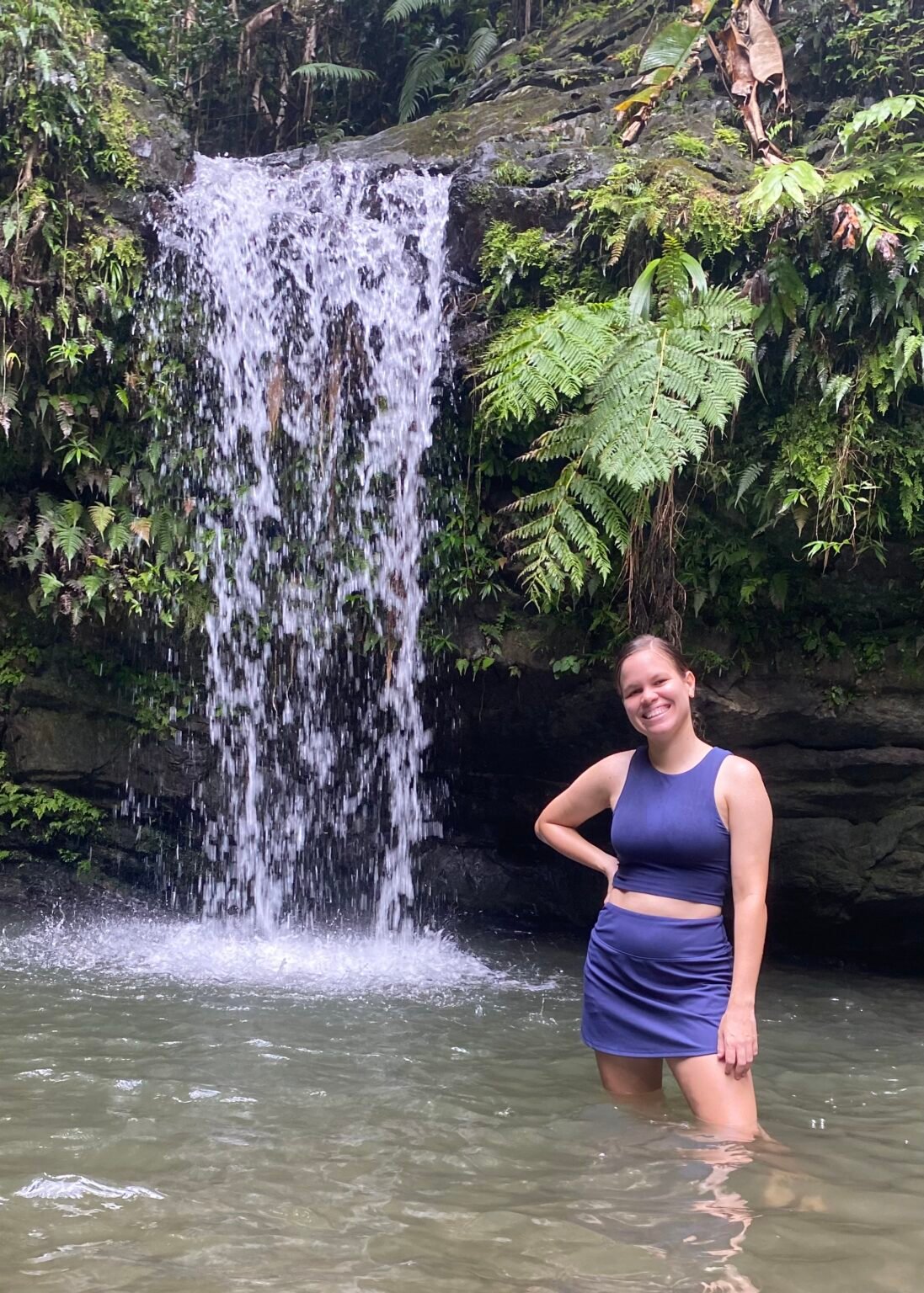 Angélica está en la quebrada Juan Diego. El agua le llega a las rodillas y la pequeña cascada está en el fondo