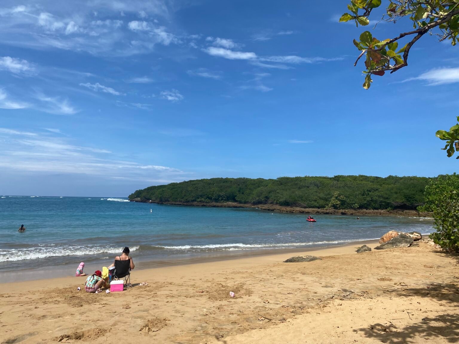 una persona sentada a la orilla de la playa vacía talega