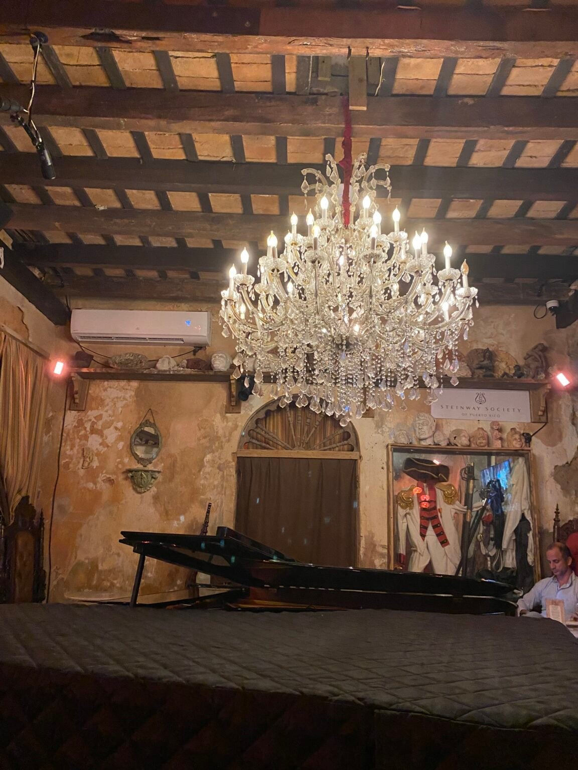 el interior de una casa en el viejo san juan con un candelabro de muchas luces y un piano