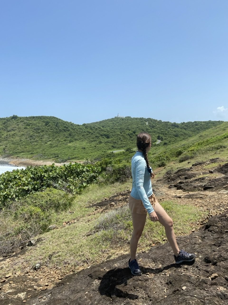 la joven mira hacia el faro de las cabezas de san juan