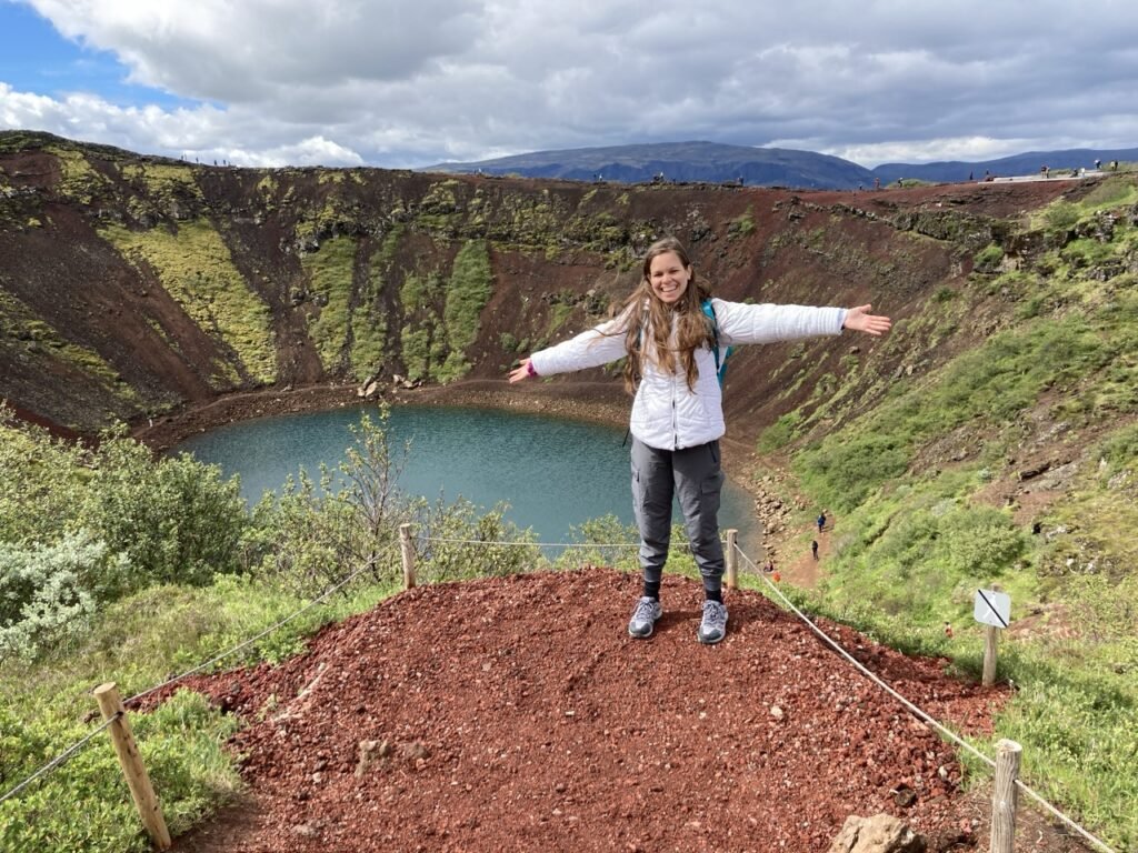La joven sonríe mientras posa para una foto al borde del cráter Kerid.