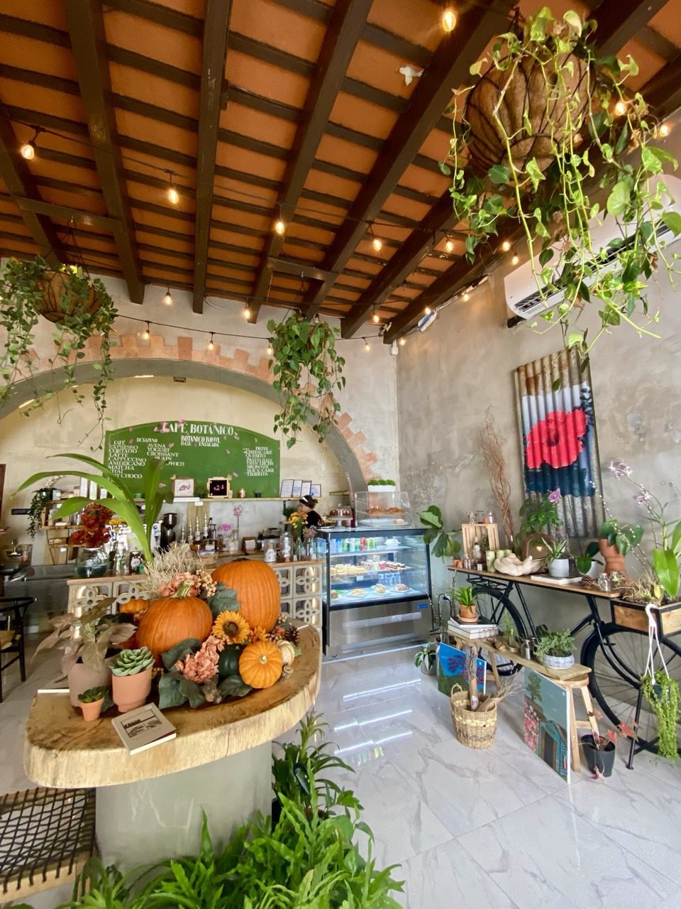 La parte interior del Café Botánico en el Viejo San Juan. Hay plantas, calabazas y flores.